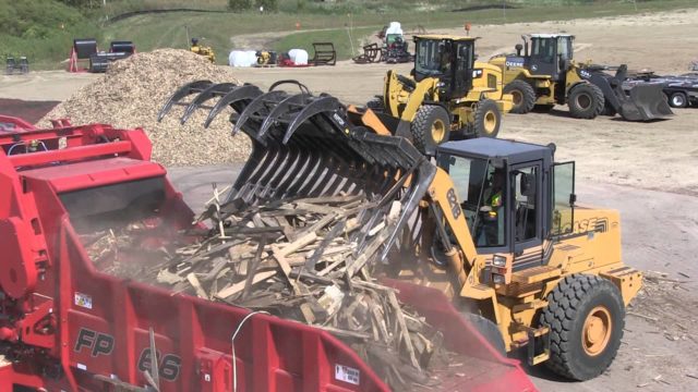 A machine placing C&D wood waste in the infeed hopper of a Rotochopper FP-66 horizontal grinder.