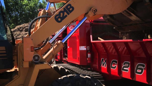 A Rotochopper MC-266 grinding machine working next to another machine at a construction site.