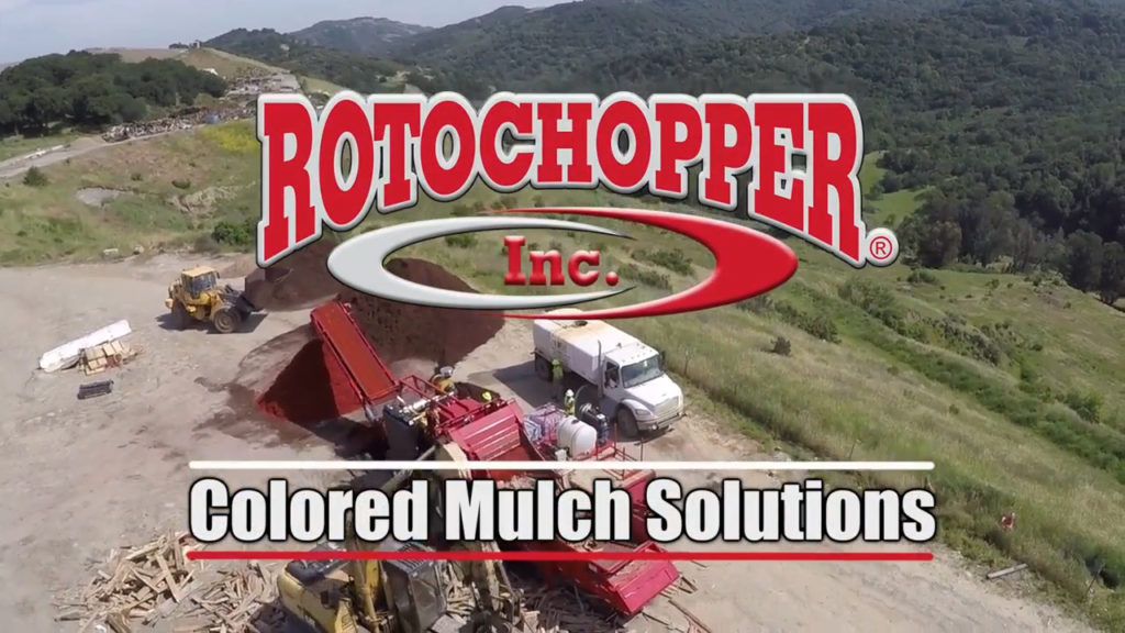 A Rotochopper grinding machine at a mulch yard with a text overlay over the image saying "Colored Mulch Solutions."