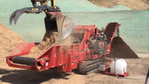 A B66 L-series Rotochopper machine processing a large volume of organic materials into colored mulch.