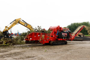 A large grinding machine demonstrates how easily it can grind trees into tiny pieces during Rotochopper's demo day event.