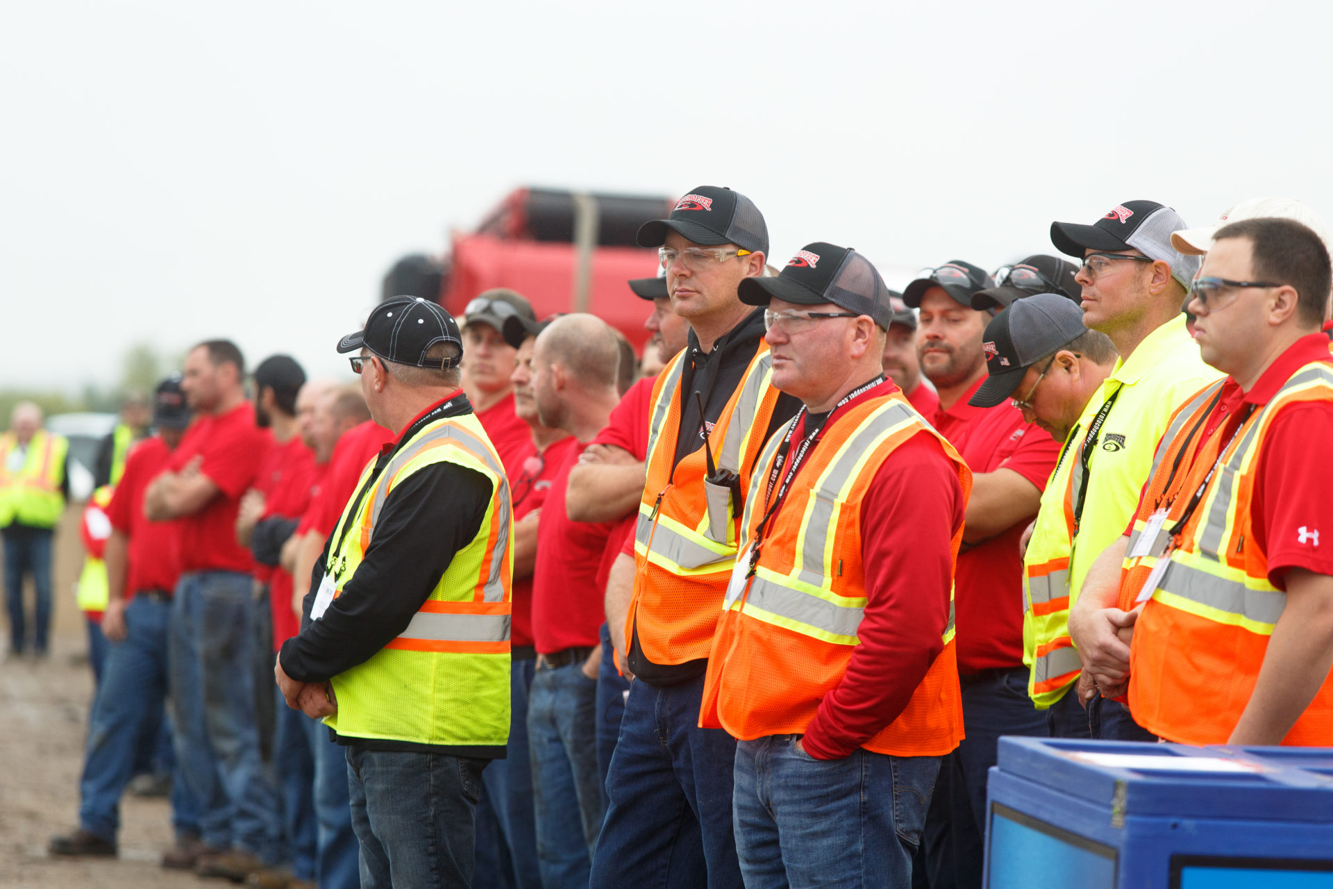 Attentive men, all wearing safety vests, engaged in a captivating demonstration during Rotochopper's demo day event.