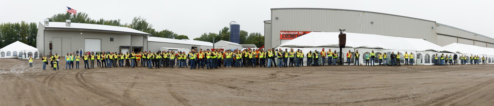 Zoomed out view of a large group of men wearing safety vests, all paying close attention to a demonstration at Rotochopper's demo day event.