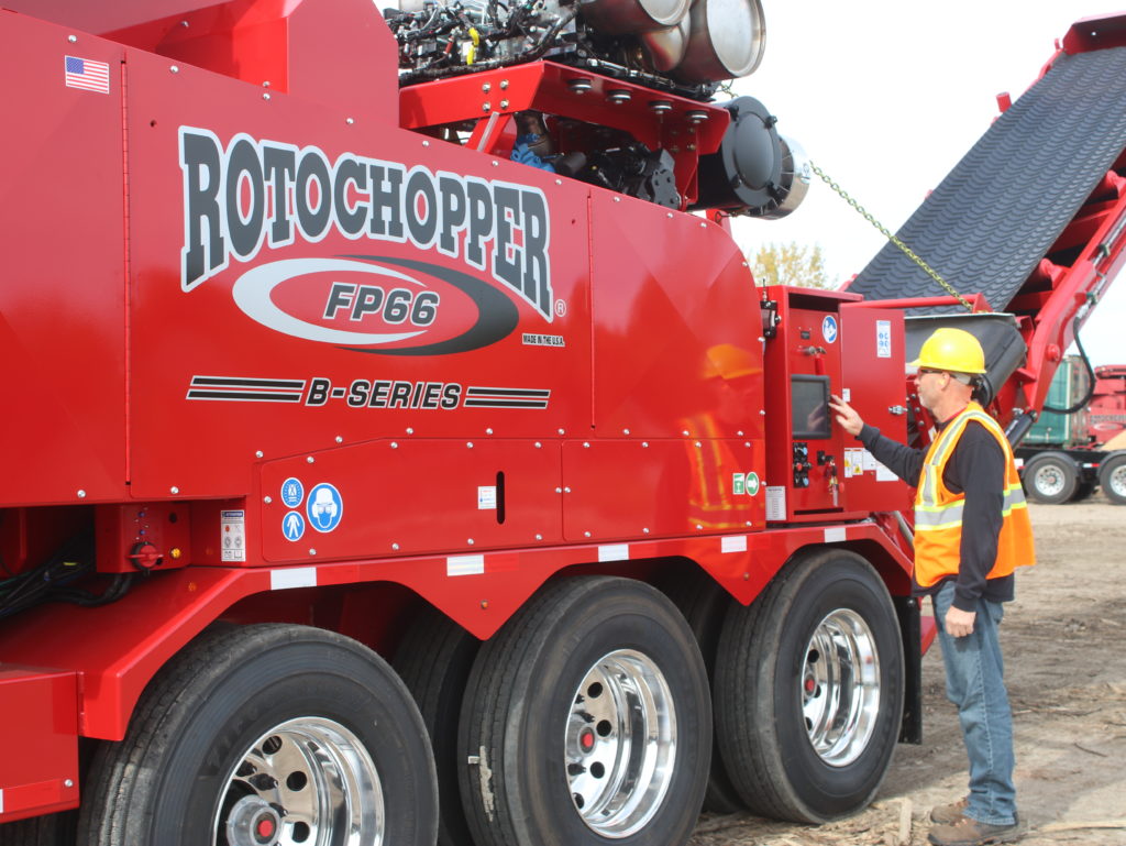 A man wearing a hard hat is working with Rotochopper's FP66 B-series machine at a grinding site