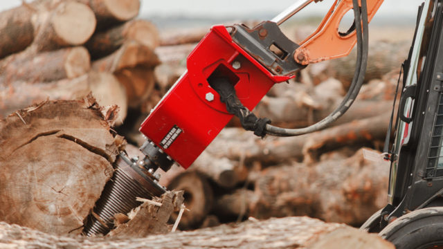 A screw splitter is shown drilling into a large tree trunk on the ground, breaking it apart.
