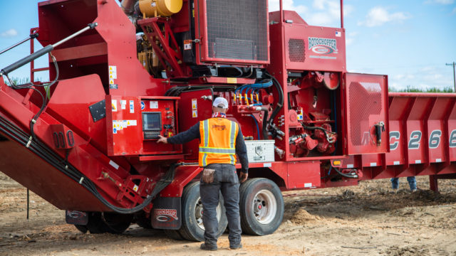 Two Rotochopper service technicians performing maintenance on a horizontal grinder.