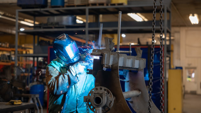 A Rotochopper welder working on a piece of horizontal grinder machinery.