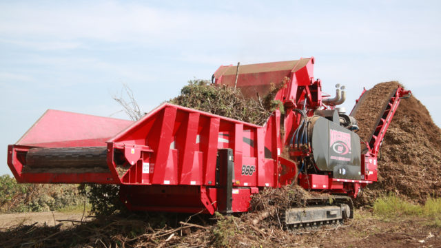 A Rotochopper horizontal grinder grinding green waste.