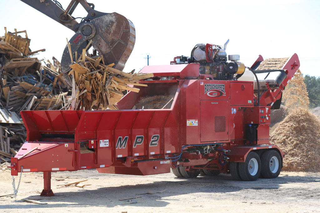 Rotochopper's MP2 grinding machines is shown efficiently grinding wood pallets into tiny pieces at a pallet recycling facility.