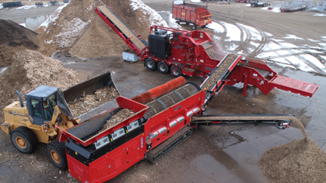 Multiple Rotochopper industrial machines working together to grind up and screen debris and place it in piles.