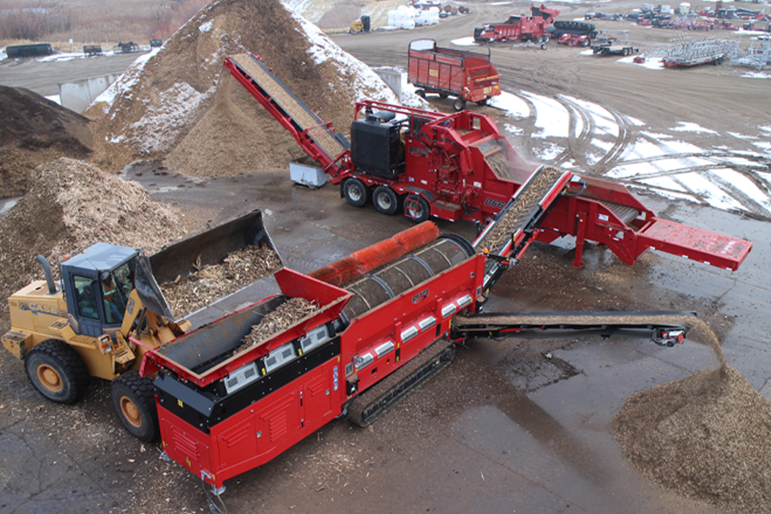 Multiple Rotochopper industrial machines working together to grind up and screen debris and place it in piles.