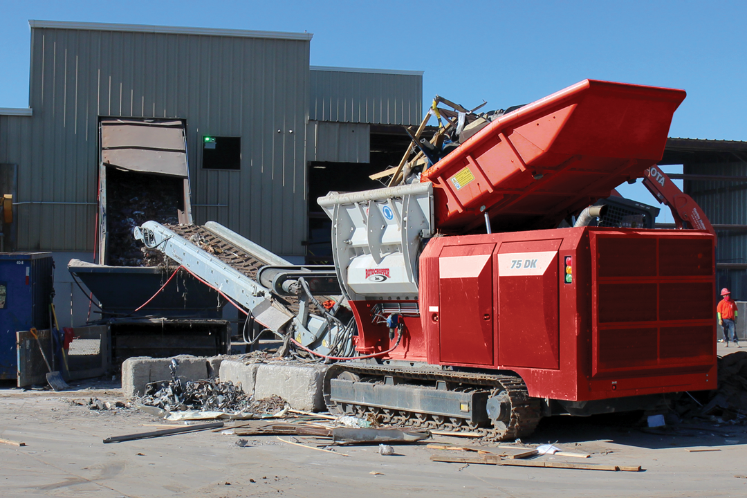 Rotochopper shredder operating outside building.