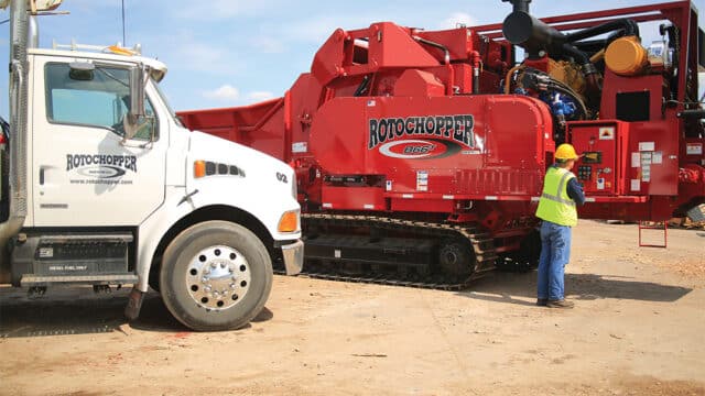 Rotochopper equipment on a job site with a worker servicing the machine