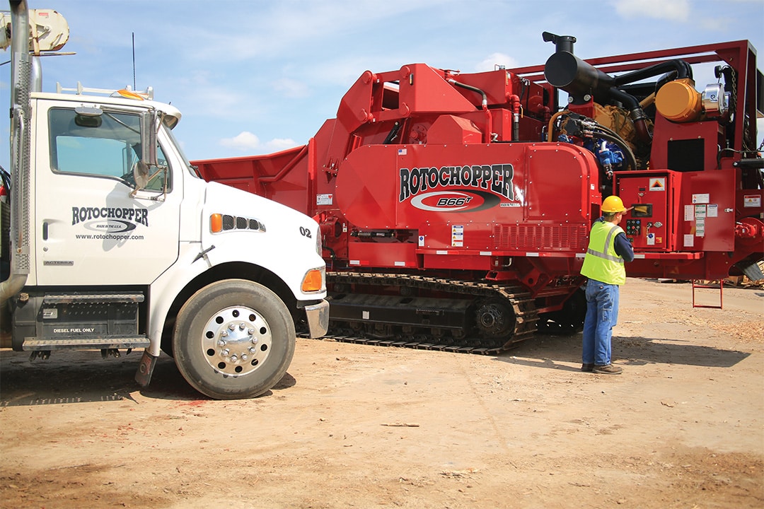 Rotochopper equipment on a job site with a worker servicing the machine