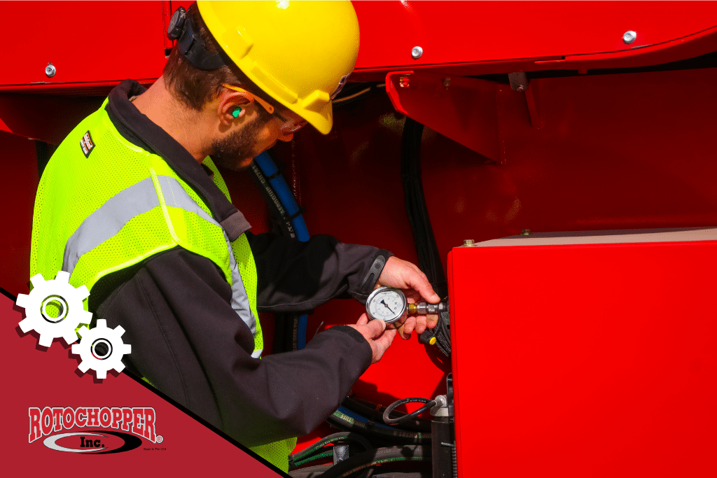 A Rotochopper service technician working on a horizontal grinder