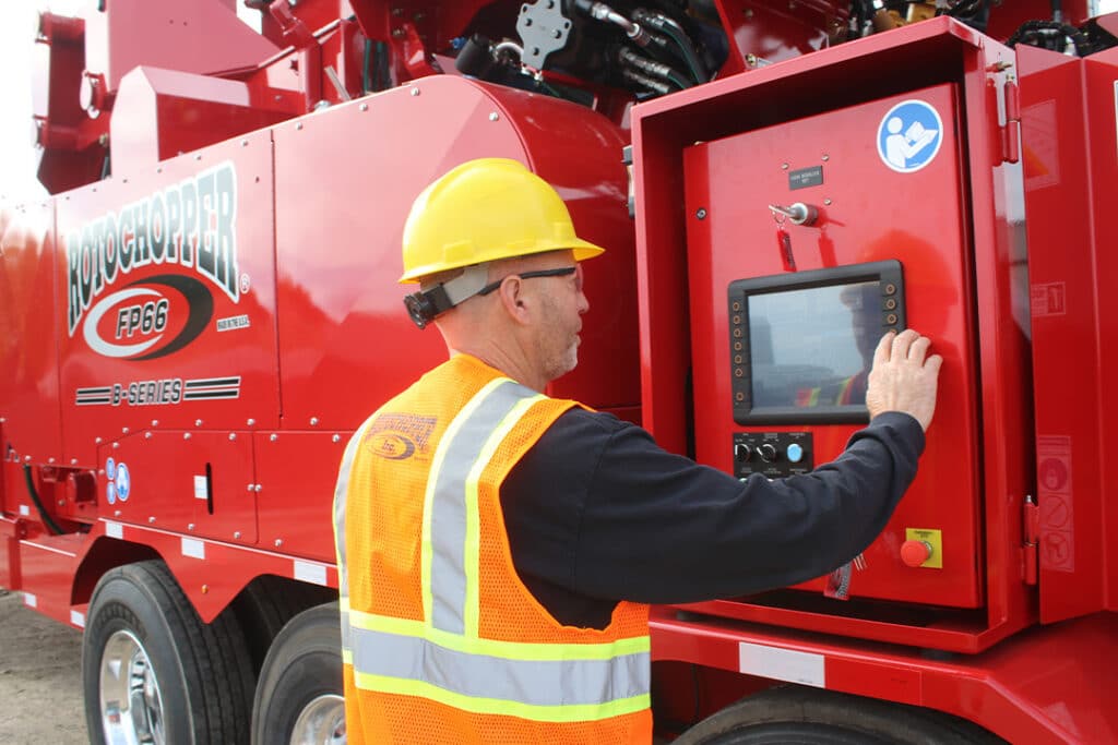 Rotochopper service tech at control panel of machine