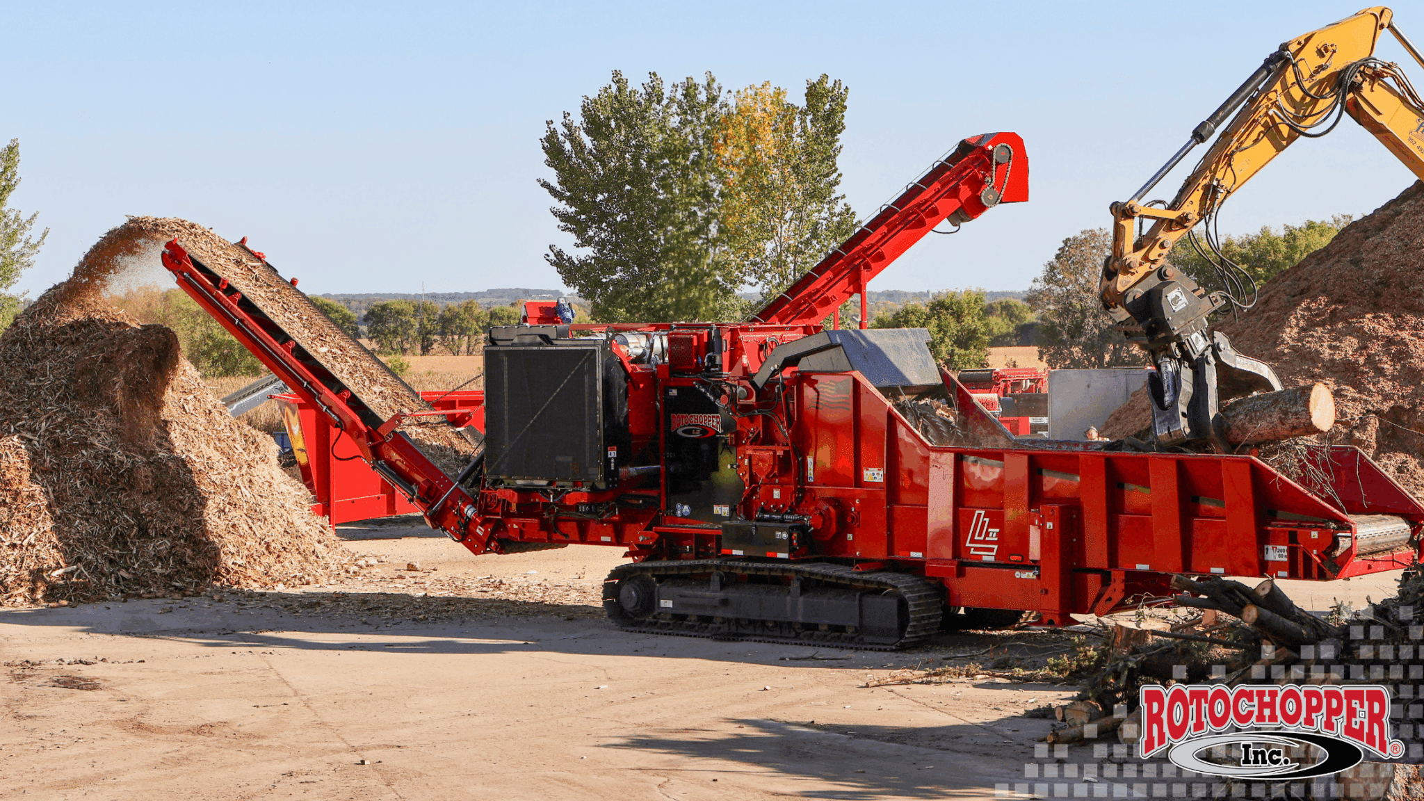 The Rotochopper L II sits on a job site grinding wood waste. The Rotochopper, Inc. logo is in the bottom right.