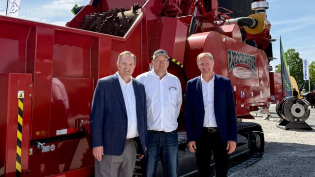 Rotochopper CEO Tosh Brinkerhoff, COO Jamey Brick, and Senior Advisor of European Operations Michael Lackner standing in front of a Rotochopper B66 horizontal grinder at IFAT Munich 2026