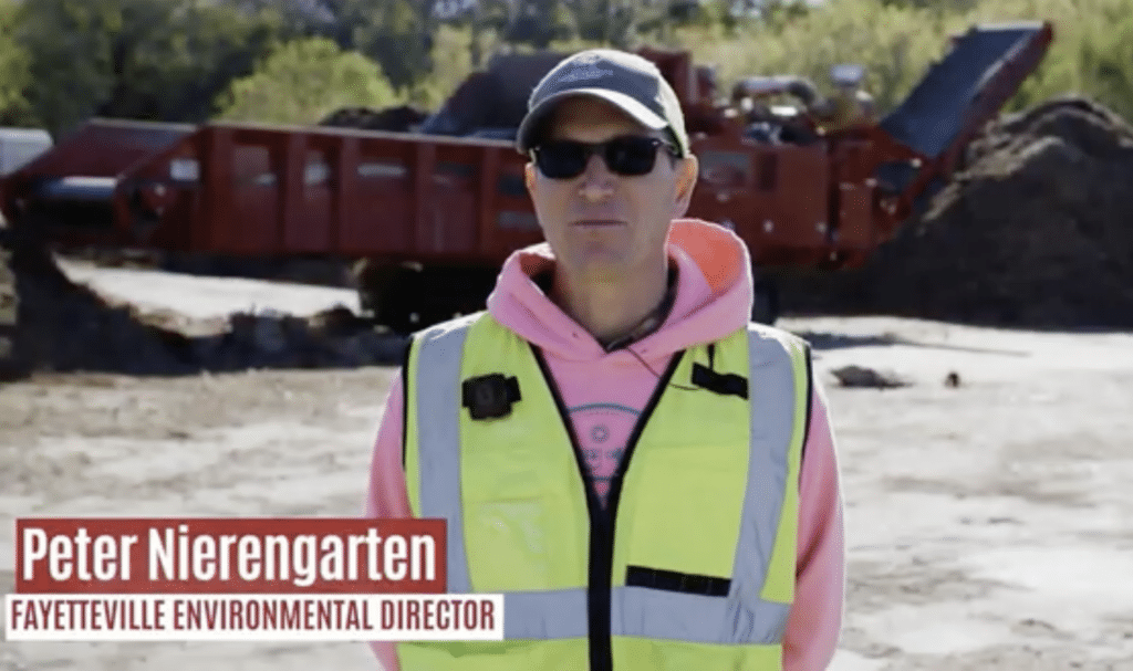 Peter Nierengarten, Environmental Director for the City of Fayetteville, Arkansas, standing in front of a Rotochopper horizontal grinder at the city's compost facility.